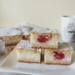 Biskvitna pita s skuto in malinami